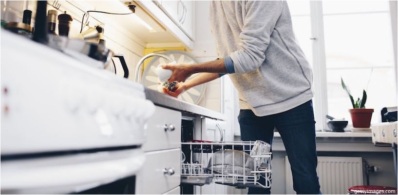 homem carregando pratos na máquina de lavar louça