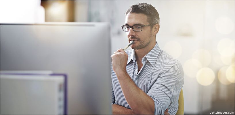 homem de óculos na frente de um monitor de computador