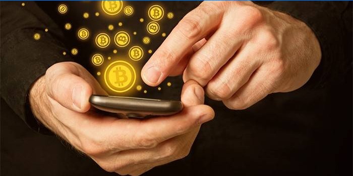 Homem com smartphone nas mãos e ícones de bitcoin.