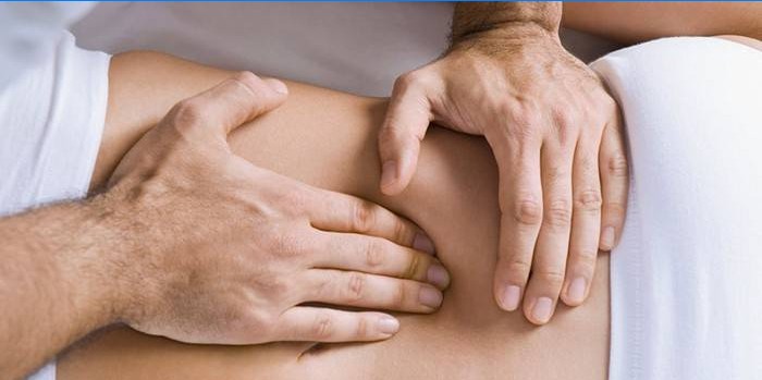 Um homem faz uma massagem nos órgãos internos do abdômen