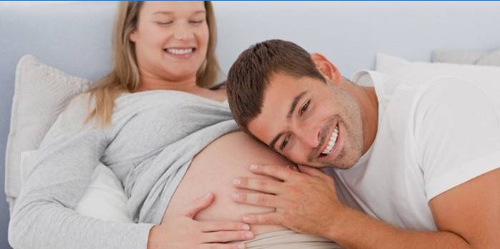 Um homem ouve um bebê se mexendo na barriga da mãe