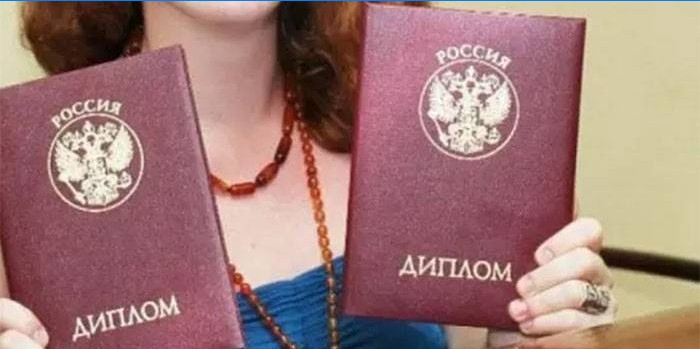 Uma menina com dois diplomas nas mãos