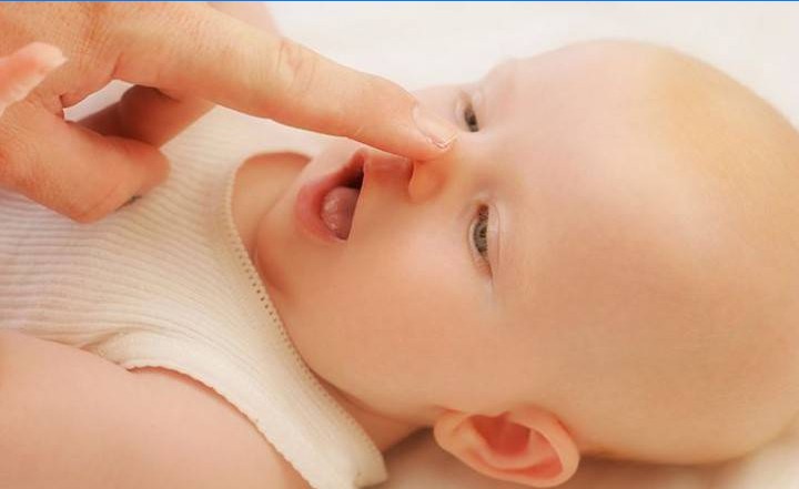 Mulher limpa o nariz de um recém-nascido