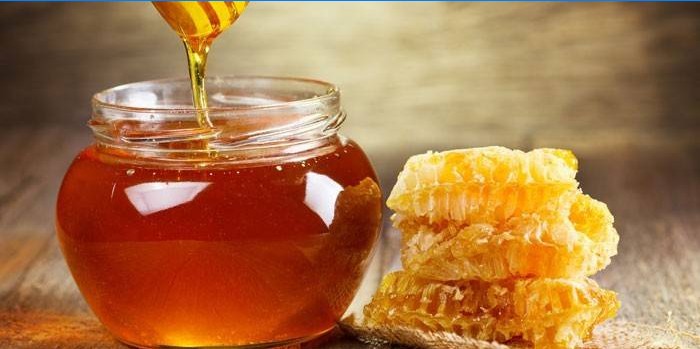 Mel em uma jarra e favos de mel