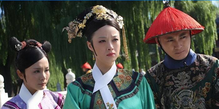 Meninas e um cara em trajes chineses nacionais