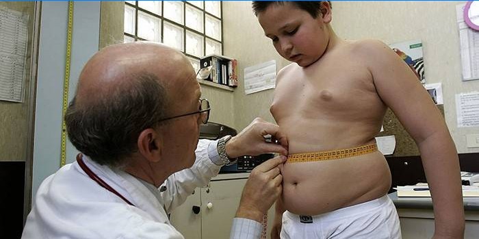 Médico mede a cintura de uma criança