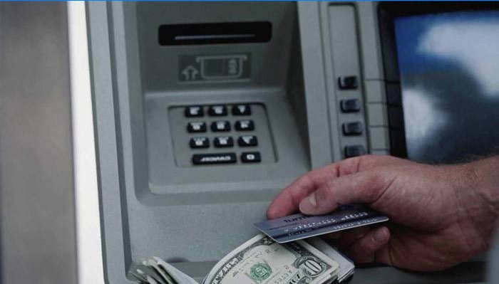 Um homem recebe dinheiro em um caixa eletrônico
