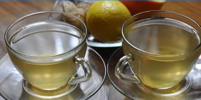 Duas xícaras de chá verde com gengibre e laranja.