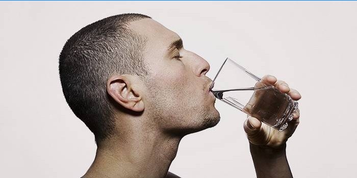 Um homem bebe água em uma dieta rápida para perda de peso