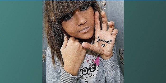 Foto de uma menina com um sinal na mão