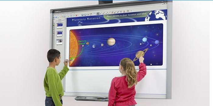 Crianças perto do quadro interativo